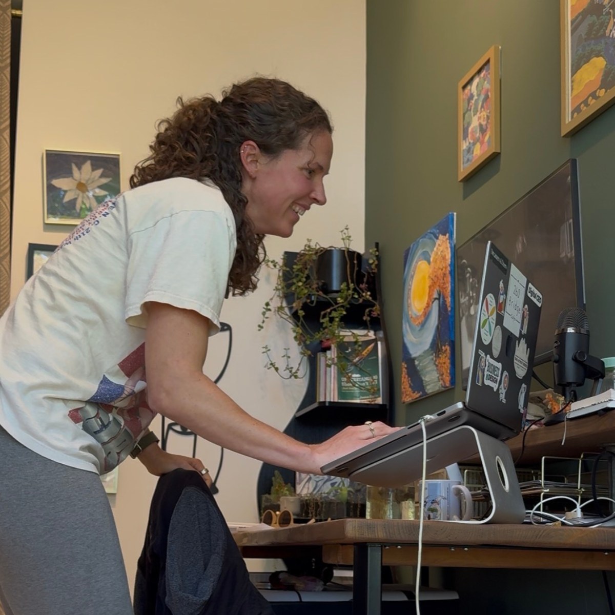 Brittany laughing at her laptop during a midday dance party